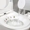 Water is being poured into a toilet seat bidet attachment. Produktbild-Vorschau