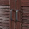 A close-up view of two dark brown cabinet doors with dark gray handles. Voir les images du produit