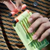 A person is loading darts into a NERF blaster magazine. Produktbild-Vorschau