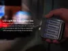 A hand holding a battery charger with batteries inside, with light emanating from it. Produktbild-Vorschau