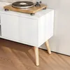 A close-up view of a white cabinet with wooden legs, featuring a turntable on top. Voir les images du produit