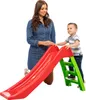 A woman and a child are standing next to a red and green children's slide. Anteprima dell’immagine prodotto