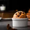 A chocolate chip muffin in a white ramekin on a dark surface. Anteprima dell’immagine prodotto
