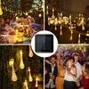 A collage of four images showing solar string lights in different settings, including a party, a garden, and a close-up of the solar panel. Produktbild-Vorschau