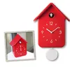 A red cuckoo clock with a pendulum is shown against a white background. A smaller inset image shows the same clock in a framed picture. Produktbild-Vorschau