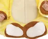 Close-up of a baby wearing a yellow costume with brown accents, focusing on the feet and hands. Voir les images du produit