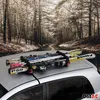 A car roof rack with skis and poles attached, set against a backdrop of a snowy forest road. Produktbild-Vorschau