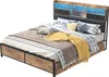 A bed with a headboard featuring LED lighting and storage compartments, dressed with pillows and a throw blanket. Produktbild-Vorschau