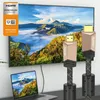 A television displaying a landscape scene, with two HDMI cables in the foreground and a laptop in the bottom left corner. Anteprima dell’immagine prodotto