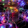 A glass jar wrapped with twine and a pink label, surrounded by colorful LED string lights. Produktbild-Vorschau