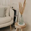 A close-up shot of a white step stool with a vase of dried flowers on top, next to a textured cream-colored sofa. Podgląd zdjęcia produktu