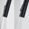 Close-up of a black faucet with water flowing from it, showing two different spray patterns. Produktbild-Vorschau