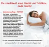 A woman is lying on a bed with a pillow, smiling. Produktbild-Vorschau