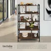 A tall, multi-shelf bookcase with various decorative items displayed on its shelves, placed in a hallway or room with large windows. Produktbild-Vorschau