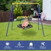 A child is sitting on a trampoline swing attached to a metal A-frame swing set in a grassy backyard. Produktbild-Vorschau