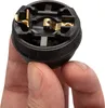 A hand holding a black electrical socket with gold contacts. Produktbild-Vorschau