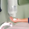 A hand is being filled with foam soap from a dispenser mounted on a wall. Náhled obrázku produktu