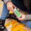 A person holding a can of coconut water outdoors, surrounded by fallen leaves. Produktbild-Vorschau