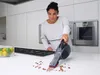 A woman is cleaning a kitchen counter with a handheld vacuum cleaner. Anteprima dell’immagine prodotto
