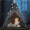 A young girl sits inside a star-patterned teepee tent, illuminated by string lights. Produktbild-Vorschau