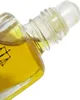 A close-up shot of the neck and cap of a small glass perfume bottle filled with yellow liquid. Voir les images du produit