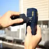 Hands holding a laser receiver outdoors with a building in the background. Produktbild-Vorschau