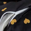 A close-up of a black duvet cover with golden heart patterns and a partially open zipper. Produktbild-Vorschau