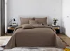 A neatly made bed with brown bedding in a bedroom setting. Produktbild-Vorschau