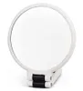 A white, round, foldable hand mirror with a black hinge is shown against a white background. Produktbild-Vorschau