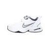A side view of a white Nike Air Monarch IV sneaker with navy accents. Náhled obrázku produktu