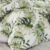 A close-up view of a comforter with a tropical leaf pattern. Produktbild-Vorschau