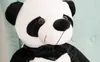Close-up of a large plush panda toy sitting on a teal chair. Voir les images du produit