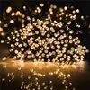 A close-up shot of a string of warm white LED lights, likely for a Christmas tree, with a reflective surface below. Podgląd zdjęcia produktu