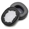 A pair of black ear pads for headphones, with one pad detached to show the inner foam and mesh. Náhled obrázku produktu