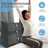 A woman is stretching while sitting on a bed next to a large wedge pillow. The pillow has grid patterns and circles with lines indicating support points. Text overlays describe the pillow's benefits. Produktbild-Vorschau