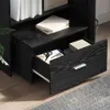 A close-up view of an open drawer in a black wood-grain filing cabinet, showing office supplies inside. Produktbild-Vorschau