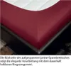 Close-up view of the corner of a red fitted sheet on a mattress. Produktbild-Vorschau