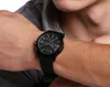 A close-up shot of a person's wrist wearing a black Armani Exchange watch. Podgląd zdjęcia produktu
