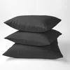 Three stacked black pillows with a striped pattern on a white background. Produktbild-Vorschau