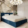 A bedroom scene featuring a dark blue upholstered bed with a beige comforter and pillows, set against a wall with a nature-themed mural and a modern chandelier. Náhľad obrázku produktu
