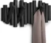 A black wall-mounted coat rack with multiple hooks, two of which are holding a beige scarf. Anteprima dell’immagine prodotto