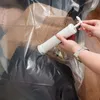 A person is using a hand pump to remove air from a vacuum storage bag filled with clothes. Produktbild-Vorschau