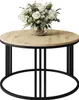 A round coffee table with a wooden top and black metal legs, decorated with a bouquet of white roses in a glass vase. Produktbild-Vorschau