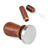 A coffee tamper and a coffee stirrer set with wooden handles and metal components are displayed against a white background. Produktbild-Vorschau
