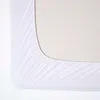 A close-up view of a white fitted sheet on a mattress. Anteprima dell’immagine prodotto