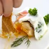 A close-up shot of a food item being eaten with a piece of bread. Podgląd zdjęcia produktu