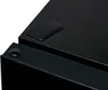 A close-up shot of the corner of a black electronic device, possibly a refrigerator, showing a protective pad and a decorative button. Produktbild-Vorschau