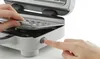 A close-up shot of hands interacting with a waffle maker. Produktbild-Vorschau