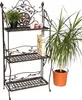 A metal shelf unit with plants and jars on it, next to a potted plant. Anteprima dell’immagine prodotto