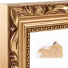 A close-up of a decorative gold picture frame with ornate detailing. Produktbild-Vorschau